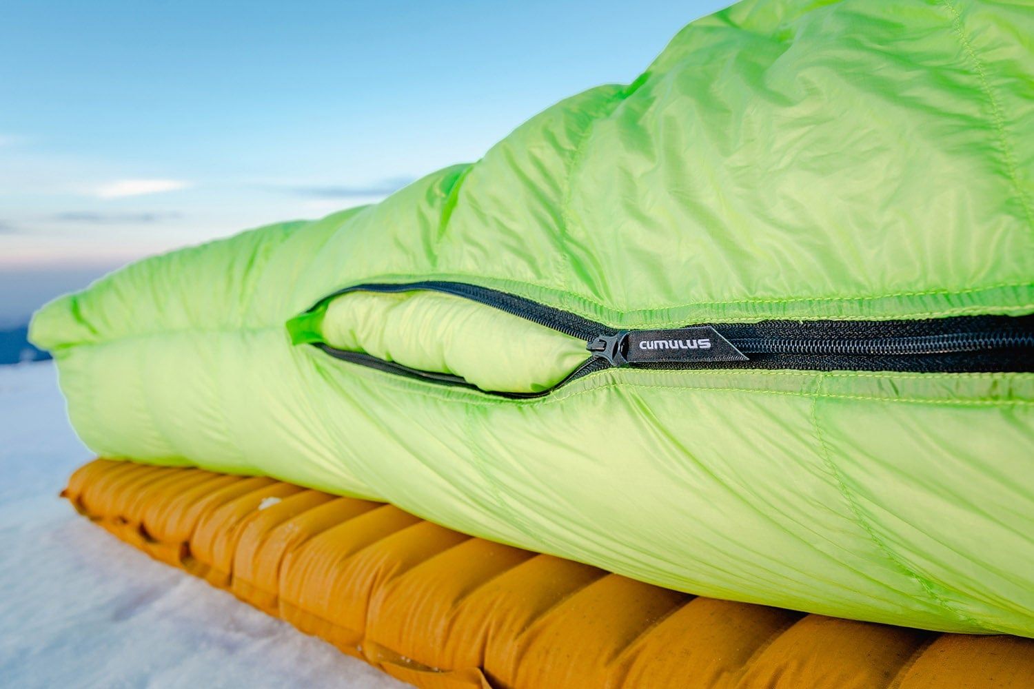 Péřový spacák Cumulus X-Lite 400 s dvoucestným zipem v zelené barvě.