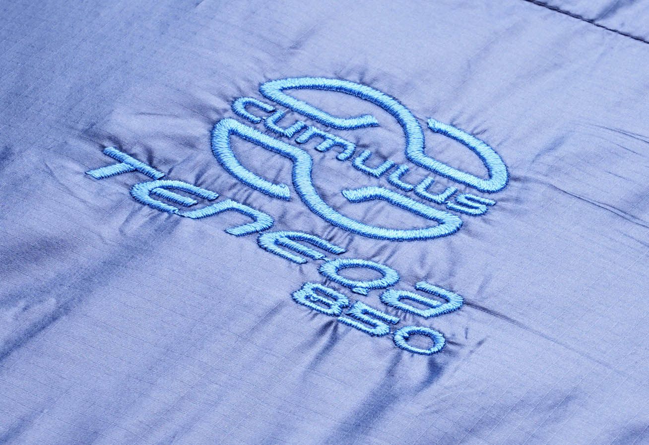 Logo péřového spacáku Cumulus Teneqa 850 v tmavě modré barvě.